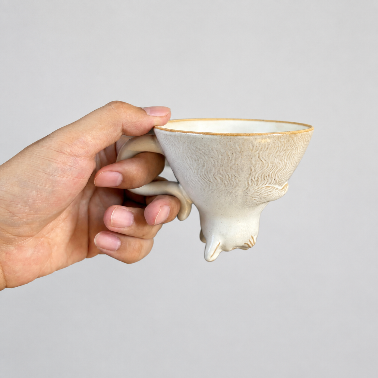 Ivory cat ceramic cup: held in hand to show relative size