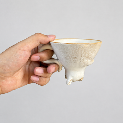Ivory cat ceramic cup: held in hand to show relative size