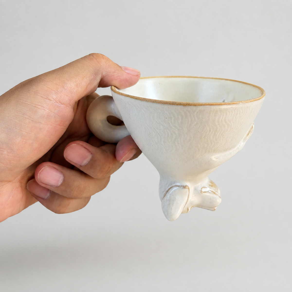 Ivory dog ceramic cup: held in hand to show relative size